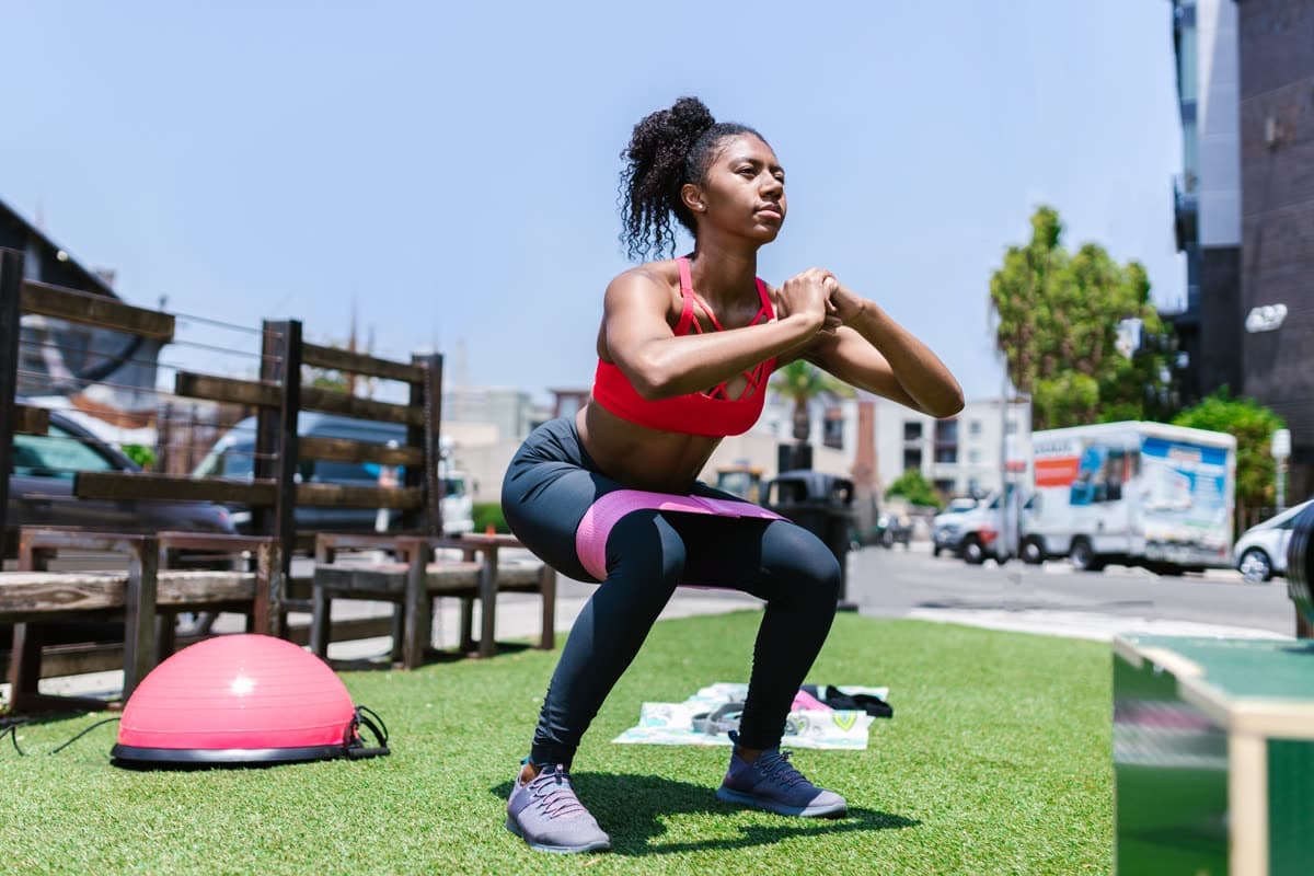 Pushing through the work, banded squats outdoors